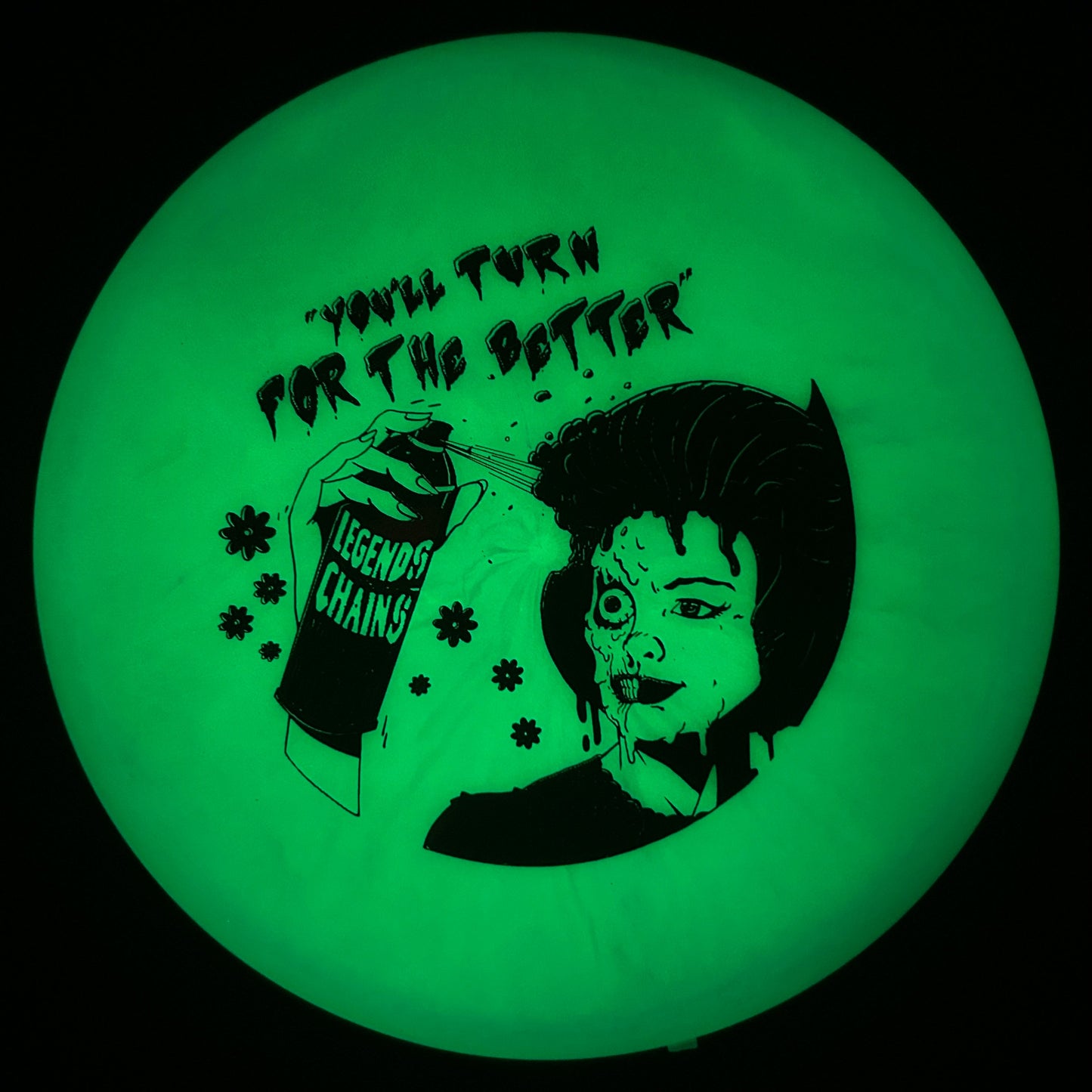 Glowing green disc with black graphic and text on a black background
